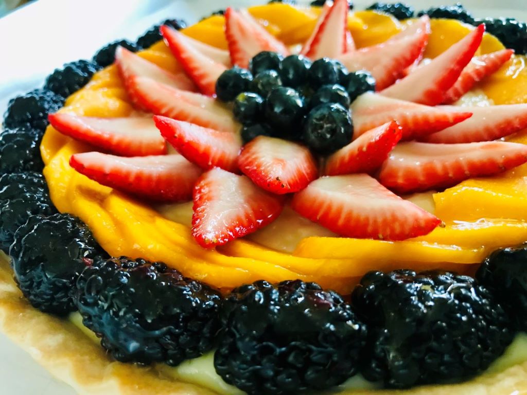 Fruit tart with fresh berries and mango